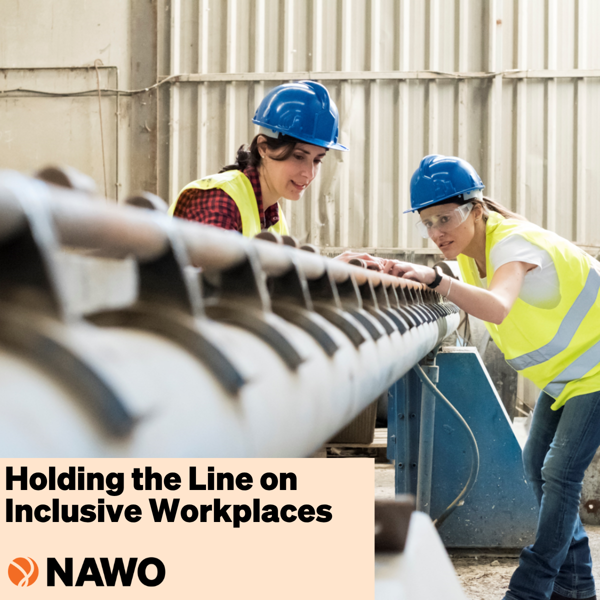 Two women in yellow vests and blue hardhats working in an operational environment